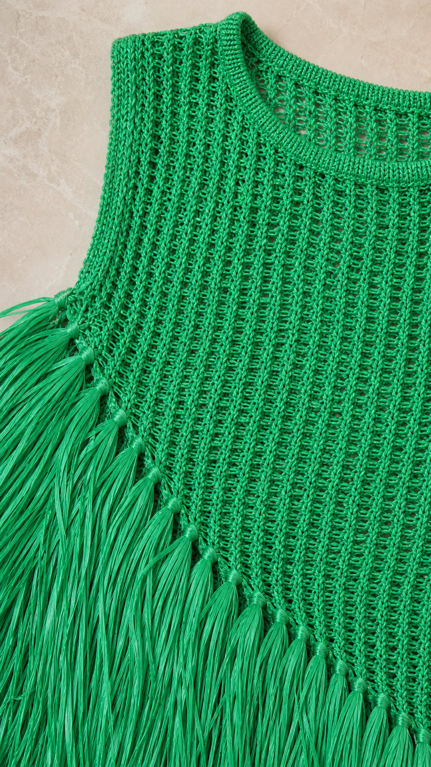 Close-up detail of green crochet knit texture and fringe