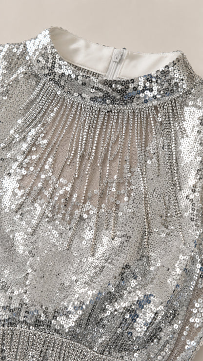 Close-up detail of silver sequin high neckline and fringe embellishment with zipper