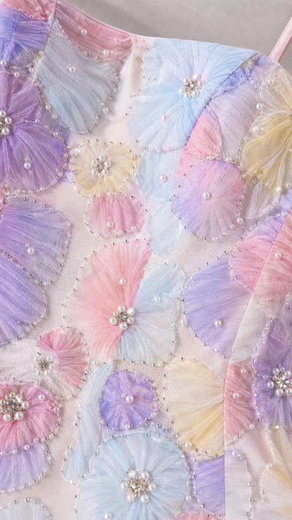 Close-up detail of 3D pleated floral appliques with pearl and rhinestone centers