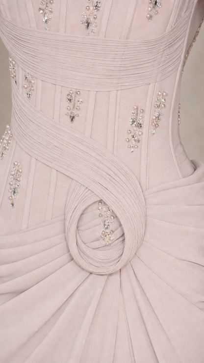Close-up detail of pleated bodice and crystal embellishments on silver grey dress