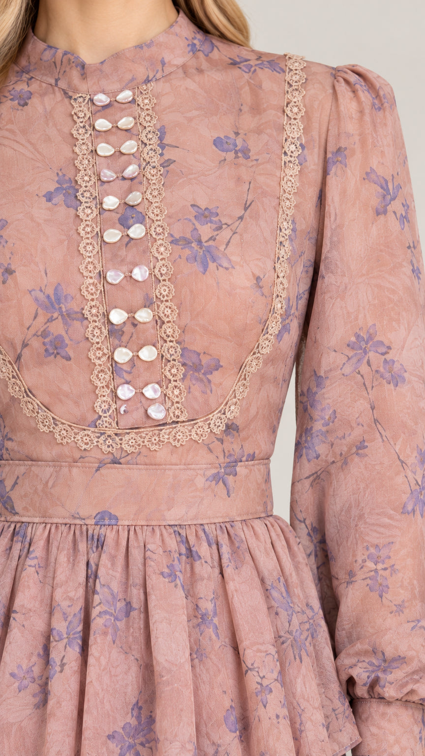 Close-up of high neck lace trim and decorative button detail on dusty rose dress