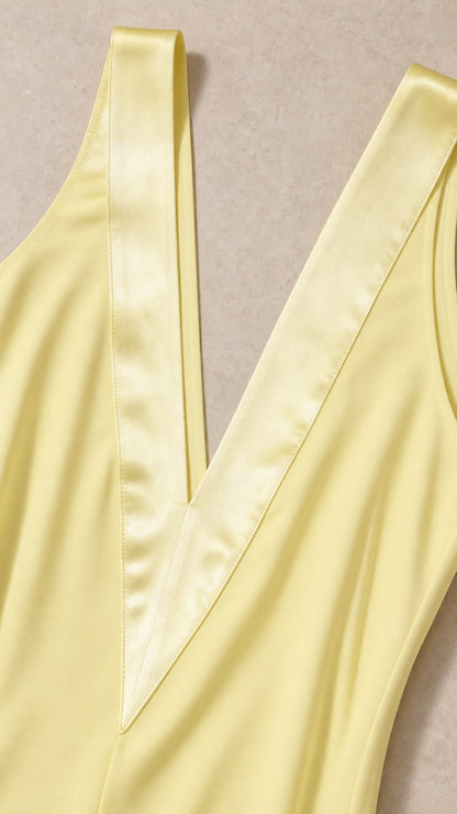 Close-up detail of satin trim on yellow V-neckline