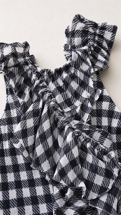 Close-up detail of textured gingham fabric and gathered ruffle neckline and trim