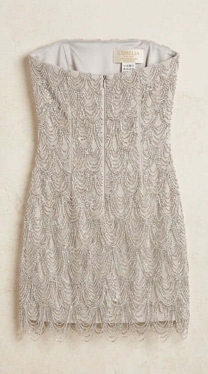 Close-up flat lay of silver beaded fringe dress showing back zipper and lining