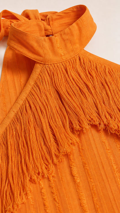 Close-up detail of the halter neckline and fringe texture in orange