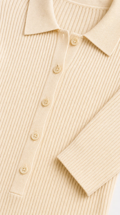 Close-up detail of cream ribbed knit fabric, collar, and button placket
