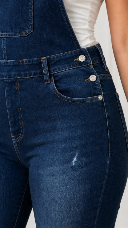 Close-up detail of side buttons and pocket on blue denim overalls