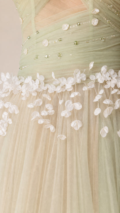 Close-up detail of sage green bodice showing beaded embellishment and delicate 3D floral appliqués