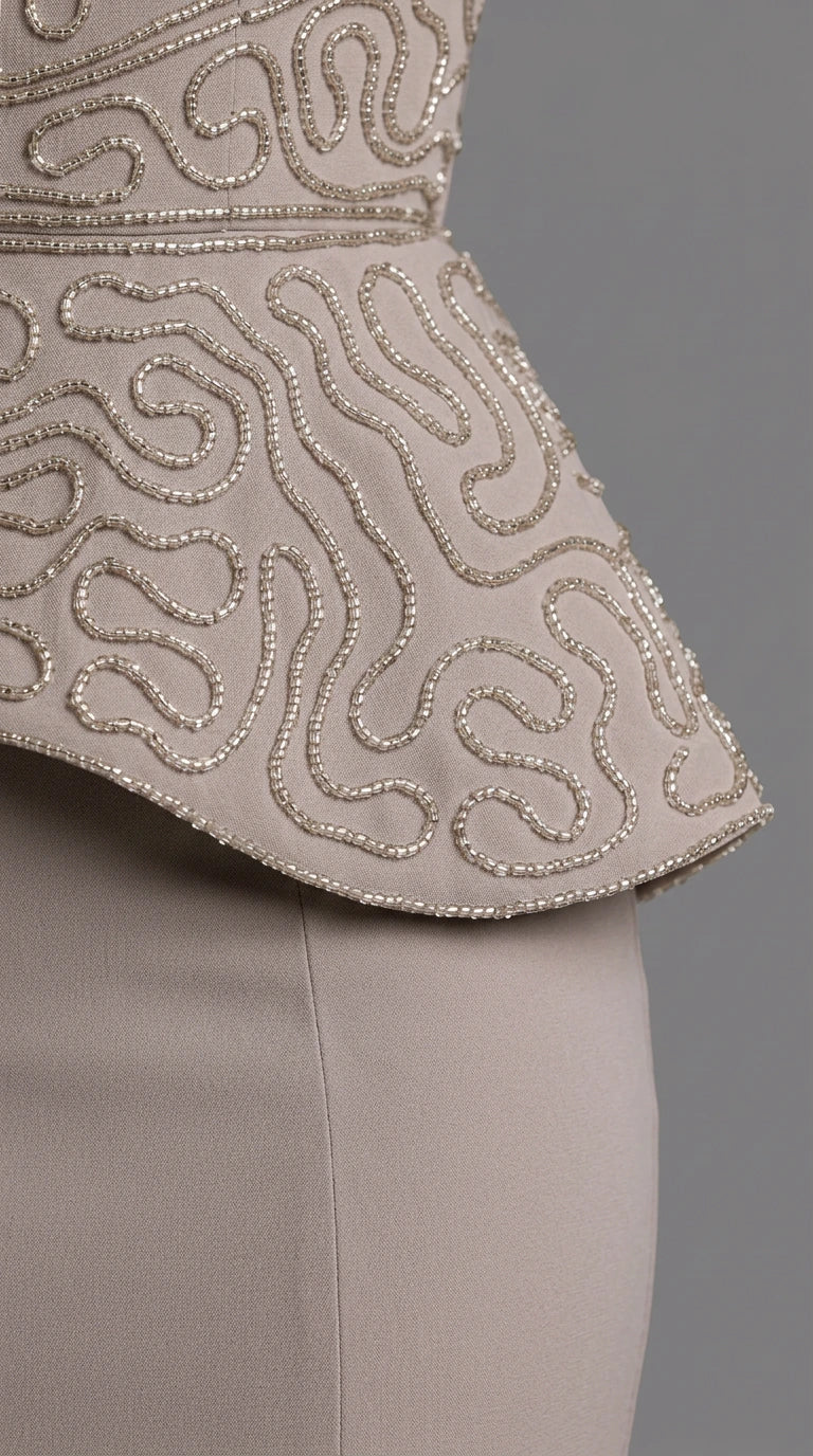 Close-up detail of textured beadwork and embroidery on peplum waistline