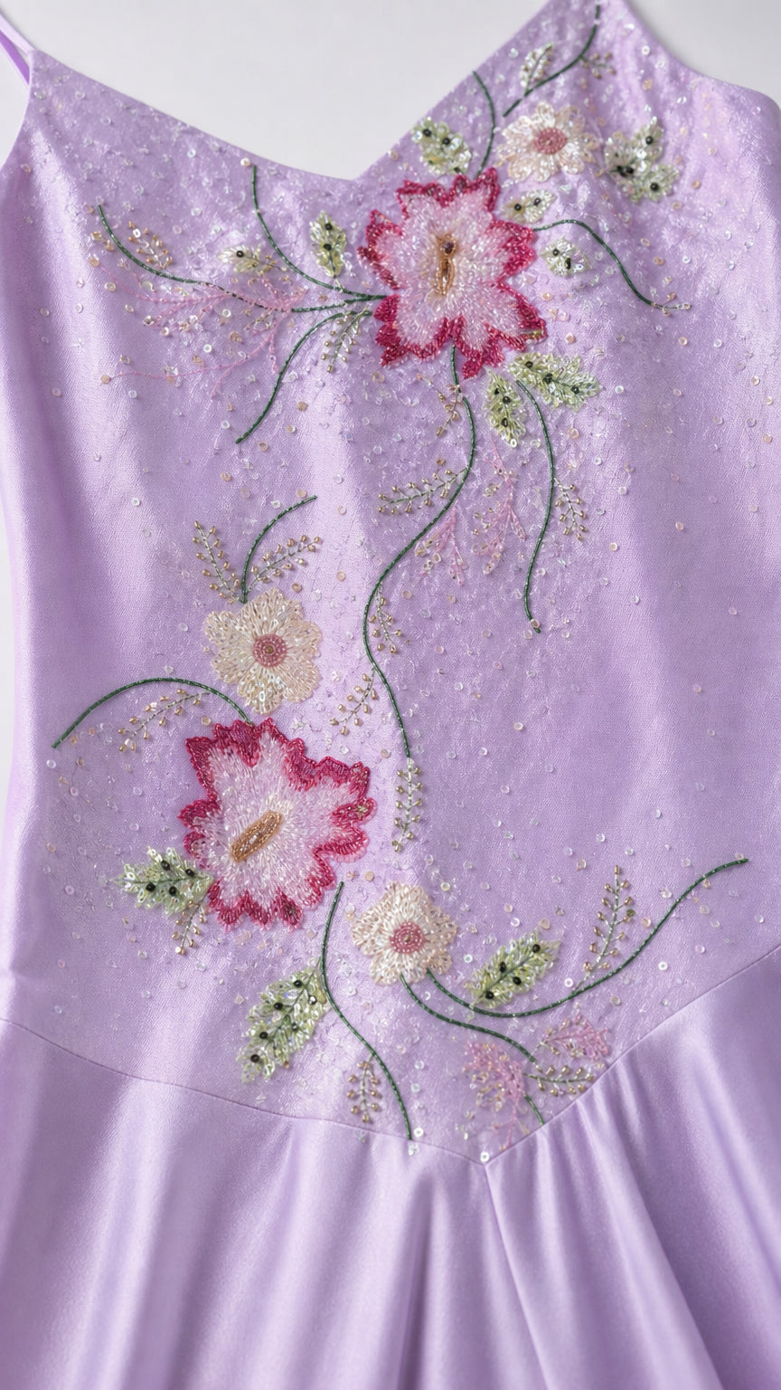 Close-up detail of floral embroidery and beading on lilac satin dress