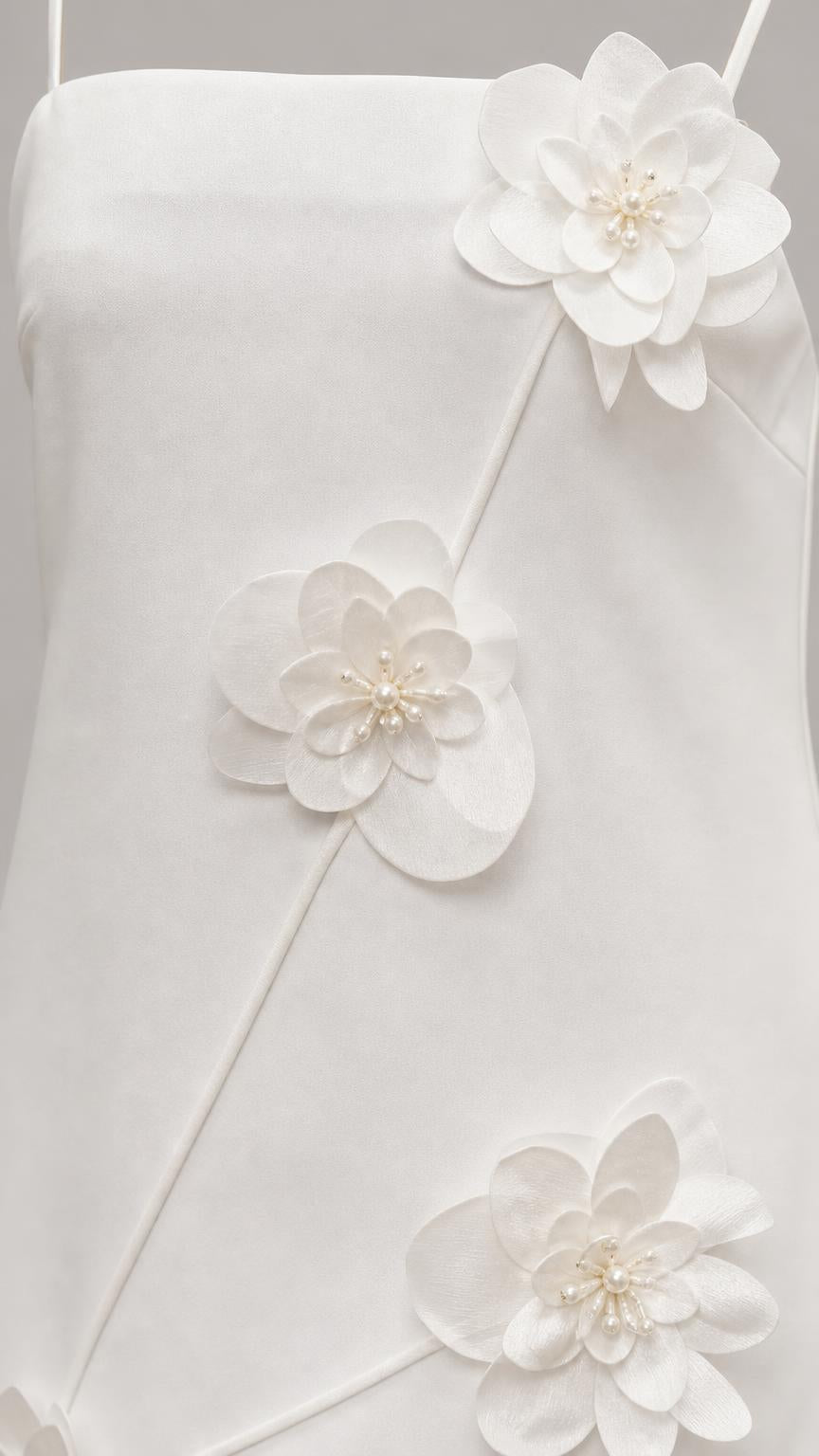 Close-up detail of 3D floral appliques with pearl centers on white dress