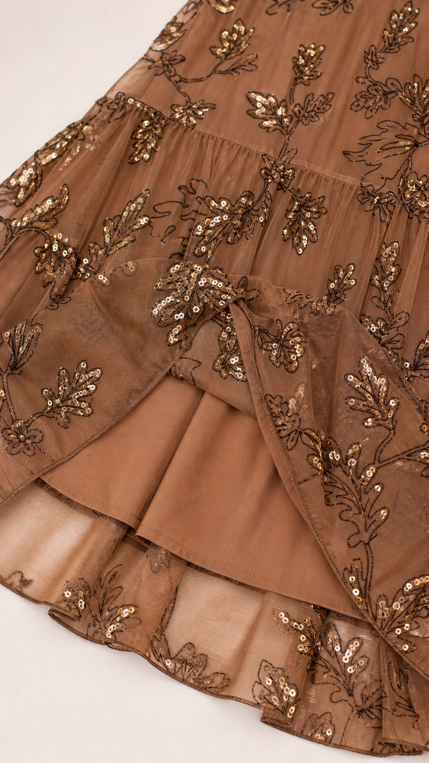 Close-up of sequin floral embroidery and tiered hem
