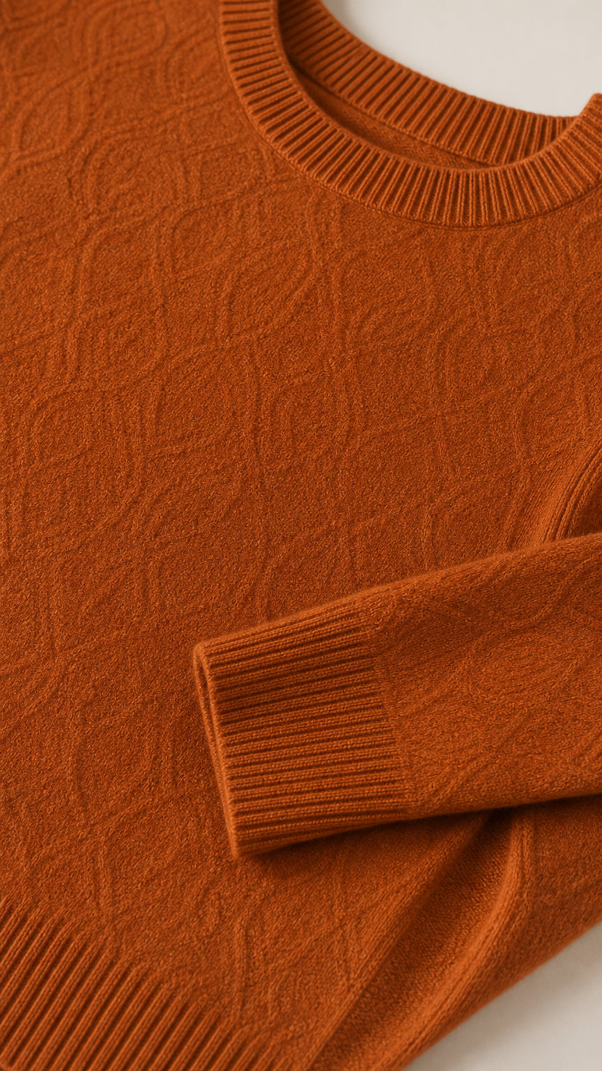 Close-up detail of textured knit fabric, ribbed neckline, and sleeve cuff in rust orange