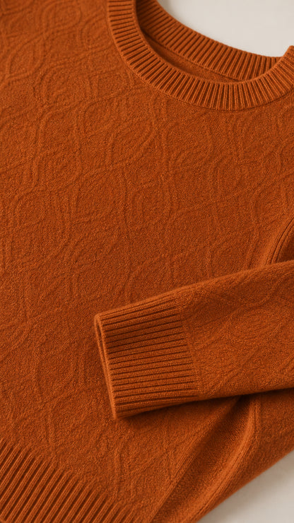 Close-up detail of textured knit fabric, ribbed neckline, and sleeve cuff in rust orange