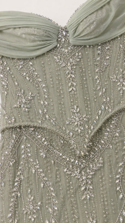 Close-up detail of beaded bodice and draped neckline in sage green