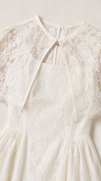 Close up view of delicate ivory lace fabric and capelet keyhole detail