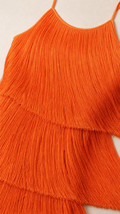Close-up detail of textured layered orange fringe tassels and thin strap neckline
