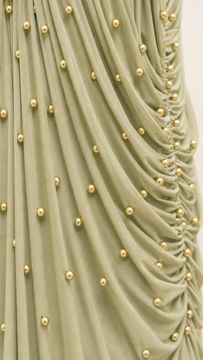 Close up detail of gathered fabric with gold-tone beaded embellishments