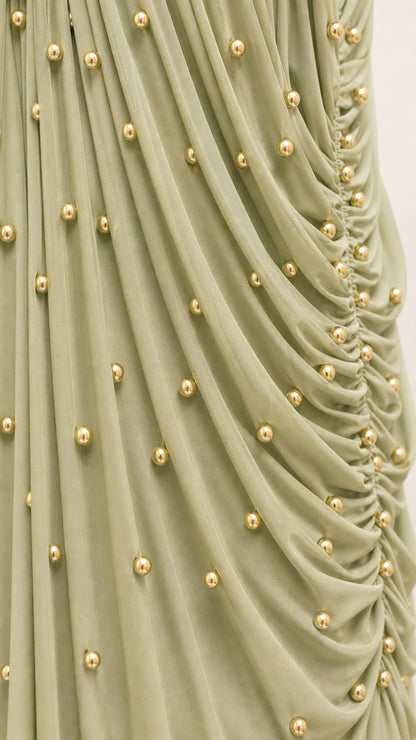 Close up detail of gathered fabric with gold-tone beaded embellishments