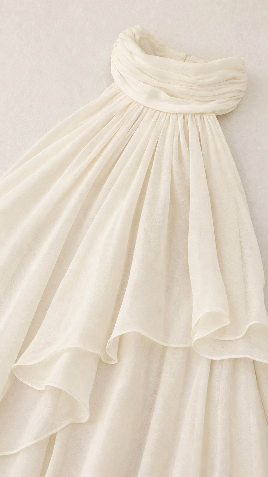 Close-up detail of gathered halter neck and layered ruffles in ivory
