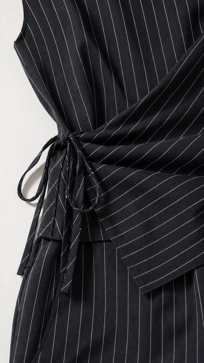 Close-up detail of the side tie wrap waist on the pinstripe jumpsuit