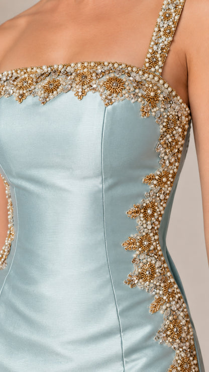 Close-up detail of ornate gold-toned beadwork, sequins, and satin fabric on square neckline