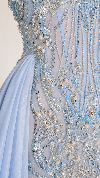 Close-up detail of intricate beadwork and sequins on light blue dress