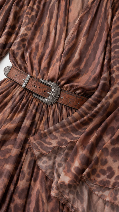 Close-up detail of western buckle belt and lightweight brown animal print fabric