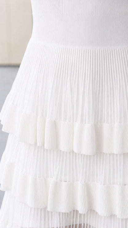Close-up detail of pleated ruffle tiers and knit texture in white