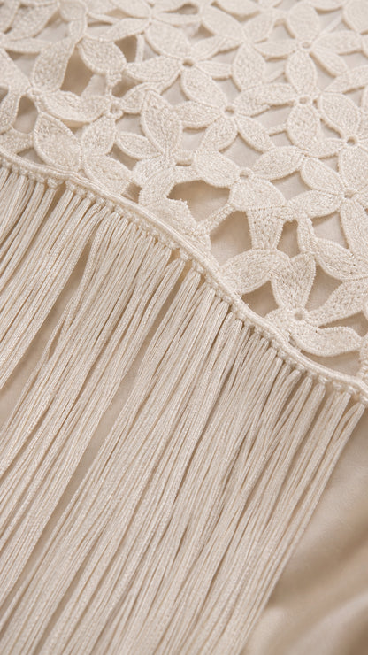 Close-up detail of white lace pattern and fringe hem