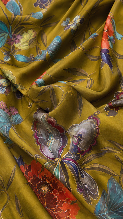 Close-up fabric detail of silky olive green textile with botanical and butterfly print