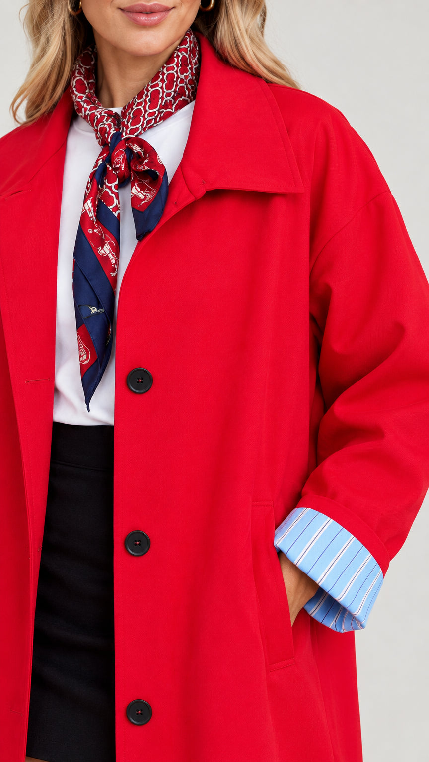 Close-up detail of Red trench coat showing lapel, front button fastening, and striped cuff lining
