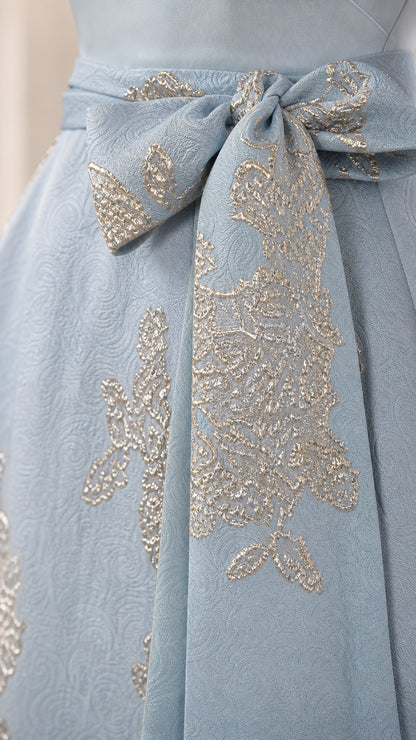 Close-up detail of the metallic floral jacquard fabric and waist tie