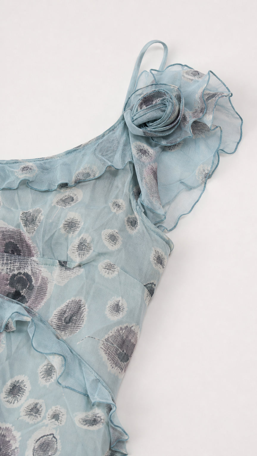 Close-up detail of 3D rosette and ruffle trim on dusty blue floral fabric