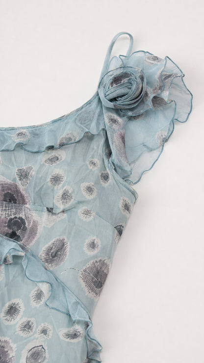 Close-up detail of 3D rosette and ruffle trim on dusty blue floral fabric