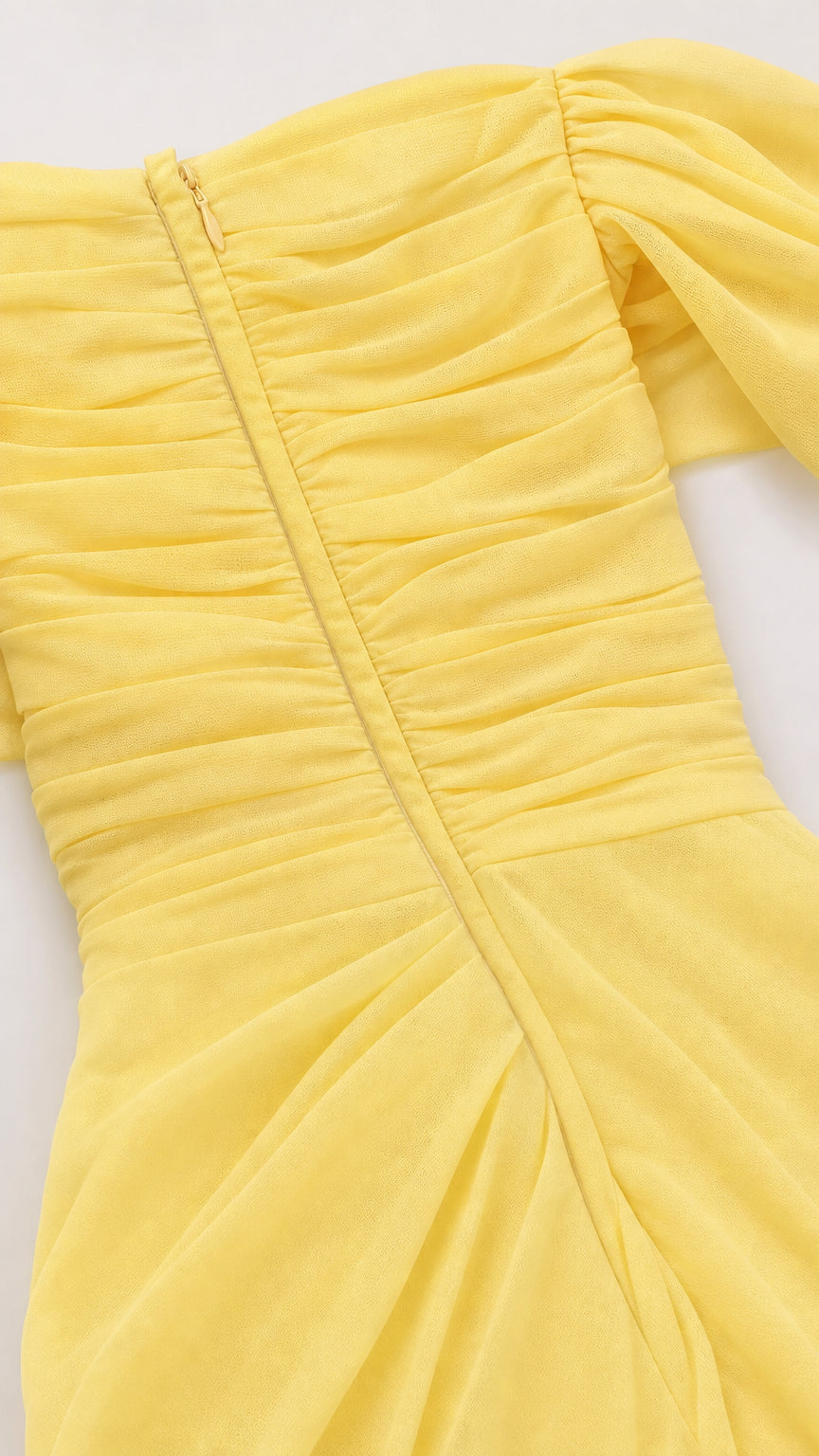 Close-up detail of back ruching and zipper on yellow dress