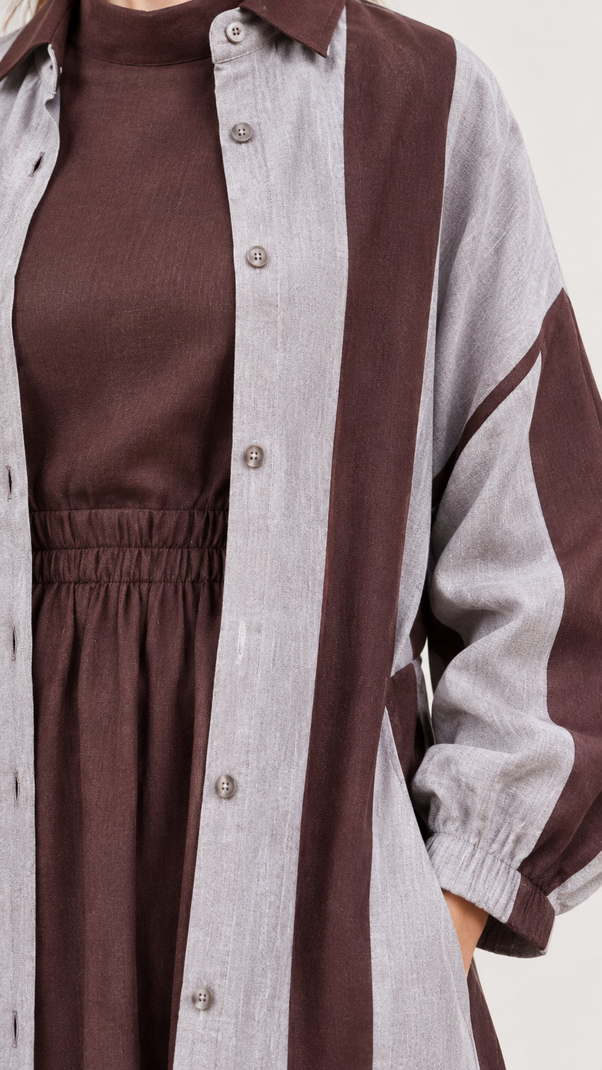 Close-up detail of fabric texture, button placket, high neckline, and elastic waist