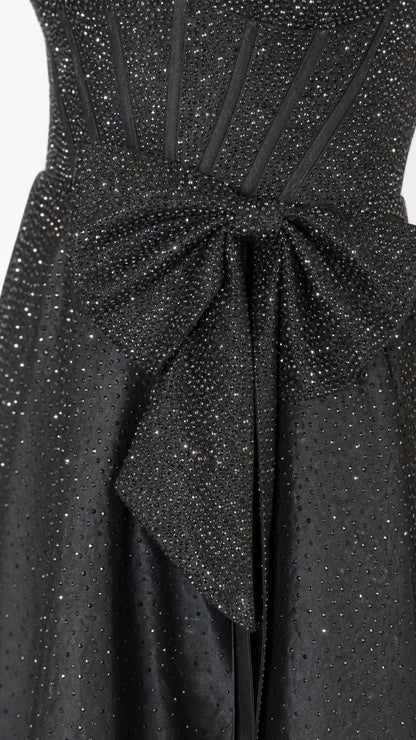 Close-up of waist bow detail on black glitter dress