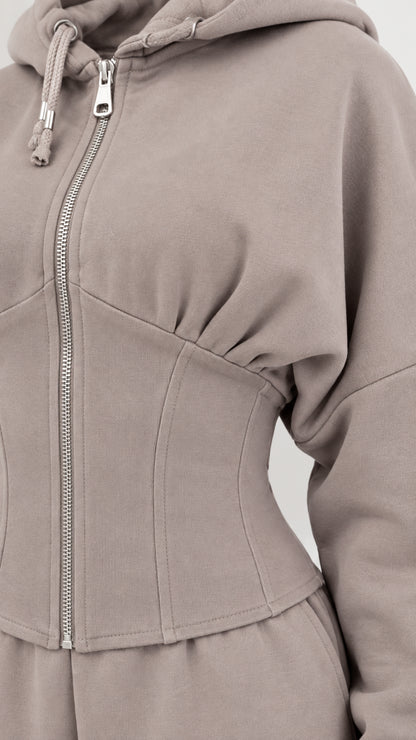 Close-up detail of taupe corset seaming and front zipper on hoodie