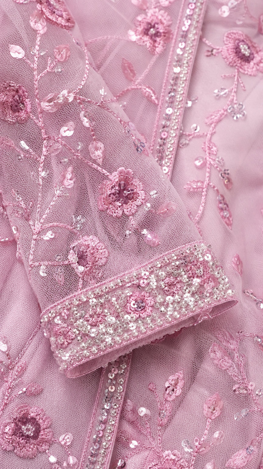 Close-up detail of floral embroidery and sequin cuffs on pink sleeve