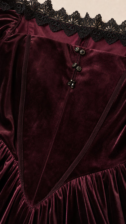 Close-up detail of black lace trim and buttons on Burgundy velvet dress