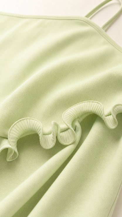 Close-up detail of fabric, spaghetti straps, and ruffle trim