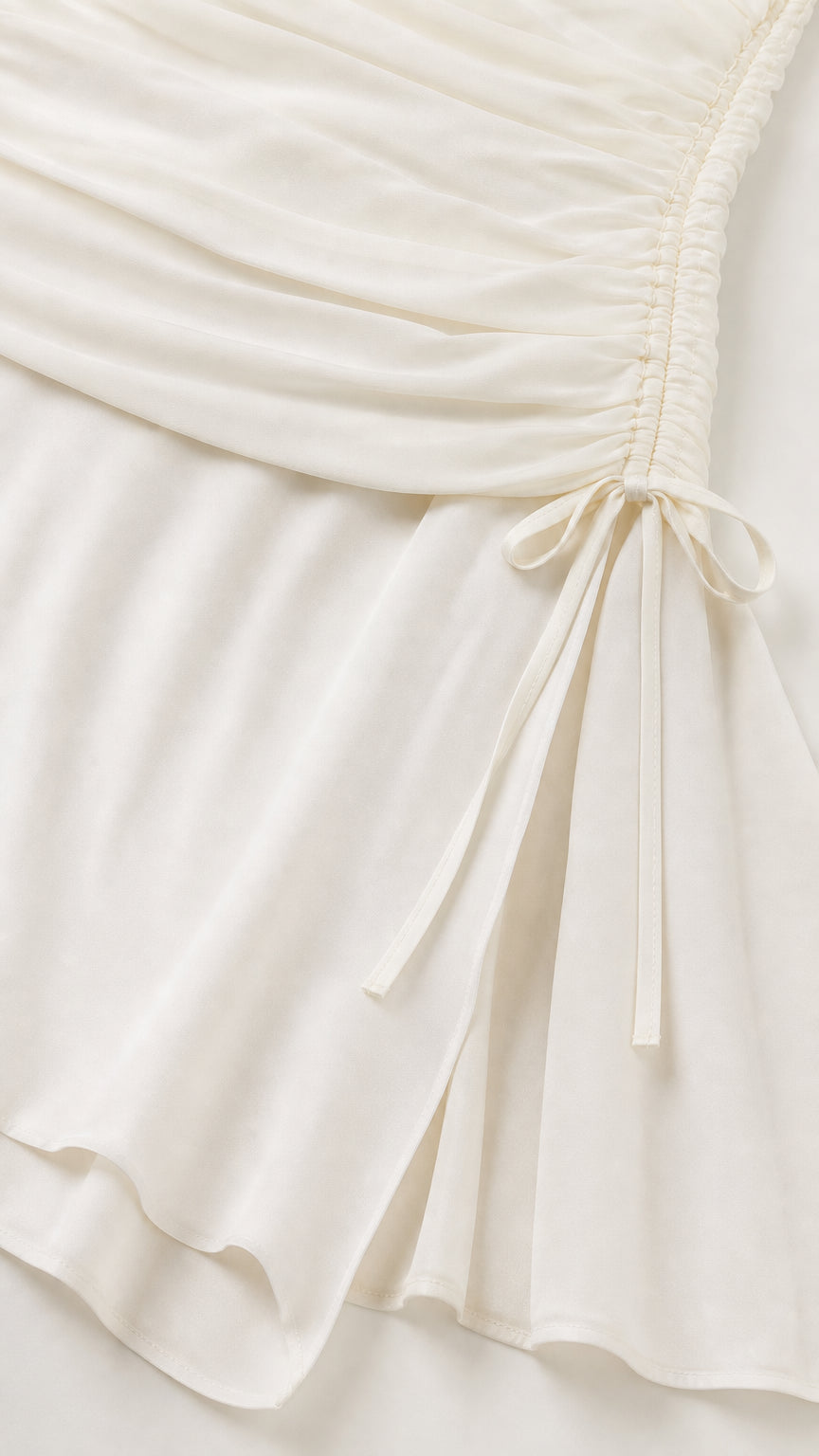 Close-up of fabric texture and drawstring side detail on white dress