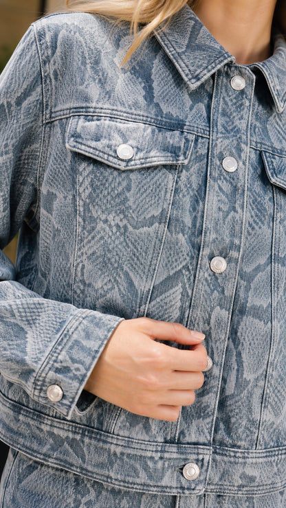 Close-up detail of denim jacket collar, buttons, and chest pocket