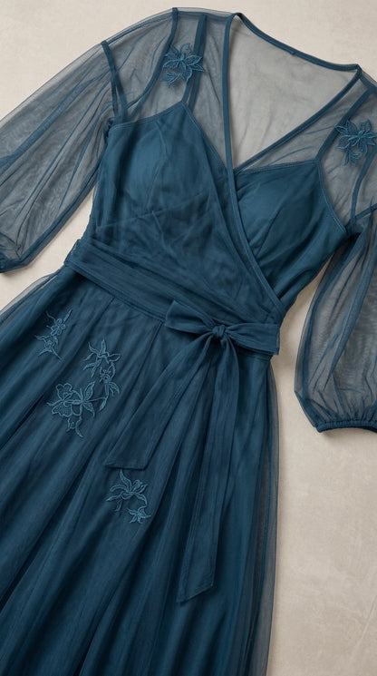 Flat lay close-up view of teal blue tulle dress showing neckline and floral embroidery