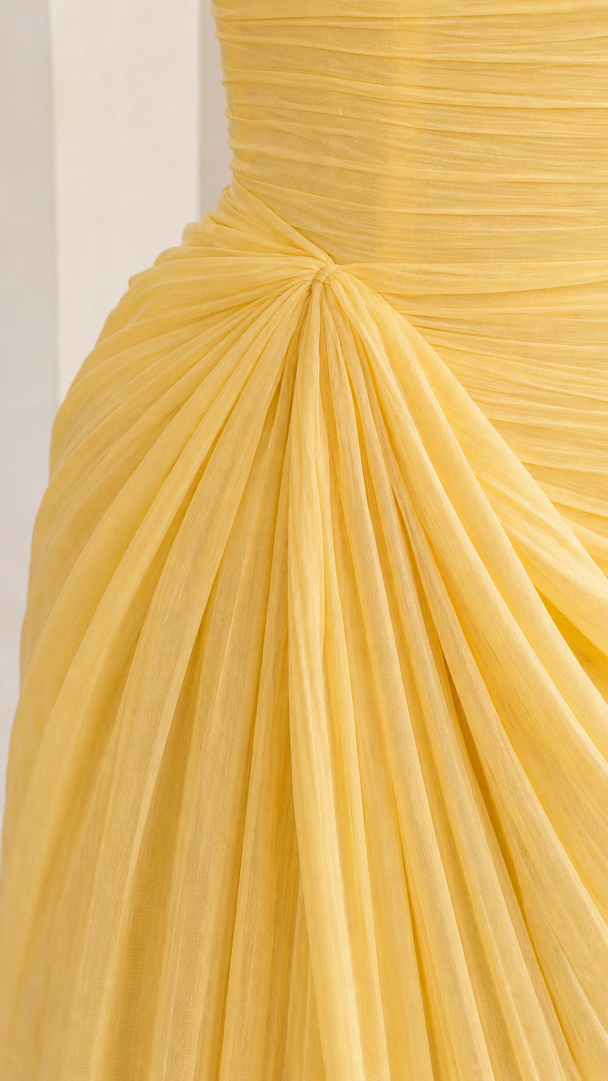 Close-up detail of fine yellow pleated ruching and gathered hip drape