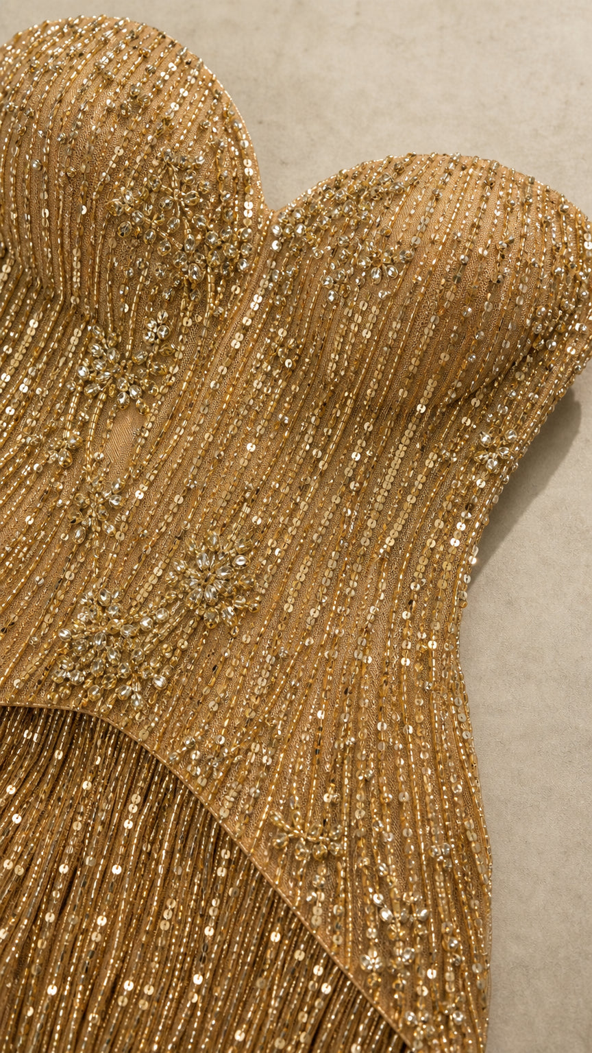 Close-up detail of gold sequin embellishments and cascading fringe bodice