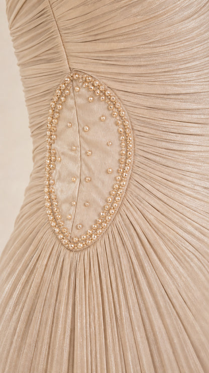 Close-up of beaded and pearl embroidered oval waist detail on champagne pleated dress