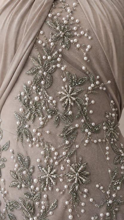 Close-up detail of delicate pearl and silver bead floral embroidery on mesh fabric