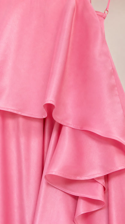 Close-up detail of smooth pink satin fabric and ruffle layers